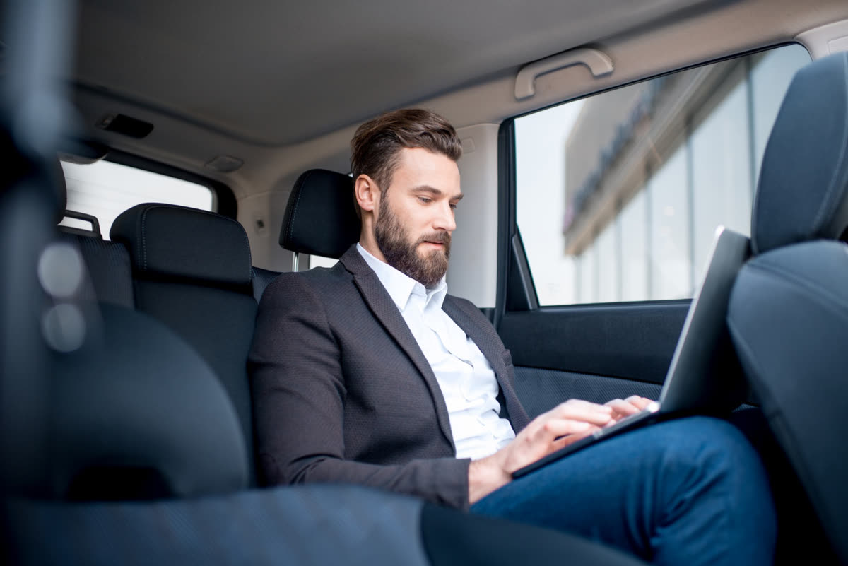 Executive working in the back seat of a car