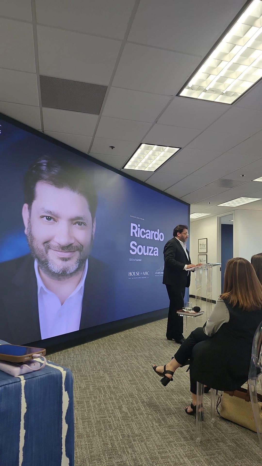 Speaker in front of an LED wall showing his portrait